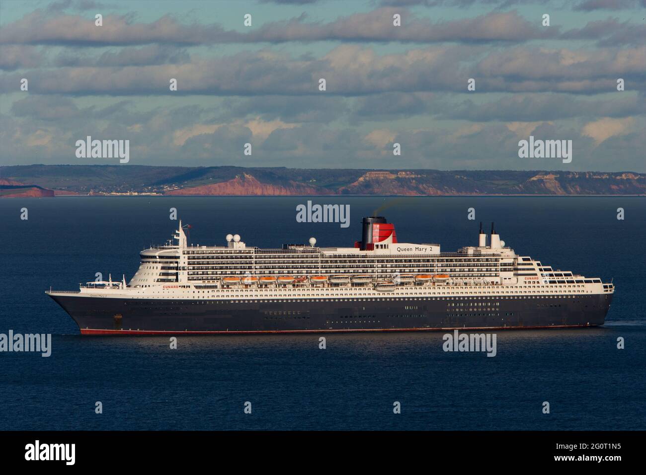 The magnificent Queen Mary 2 ocean liner cruise ship sits on calm seas whilst anchored off Torbay in Devon, UK. Stock Photo