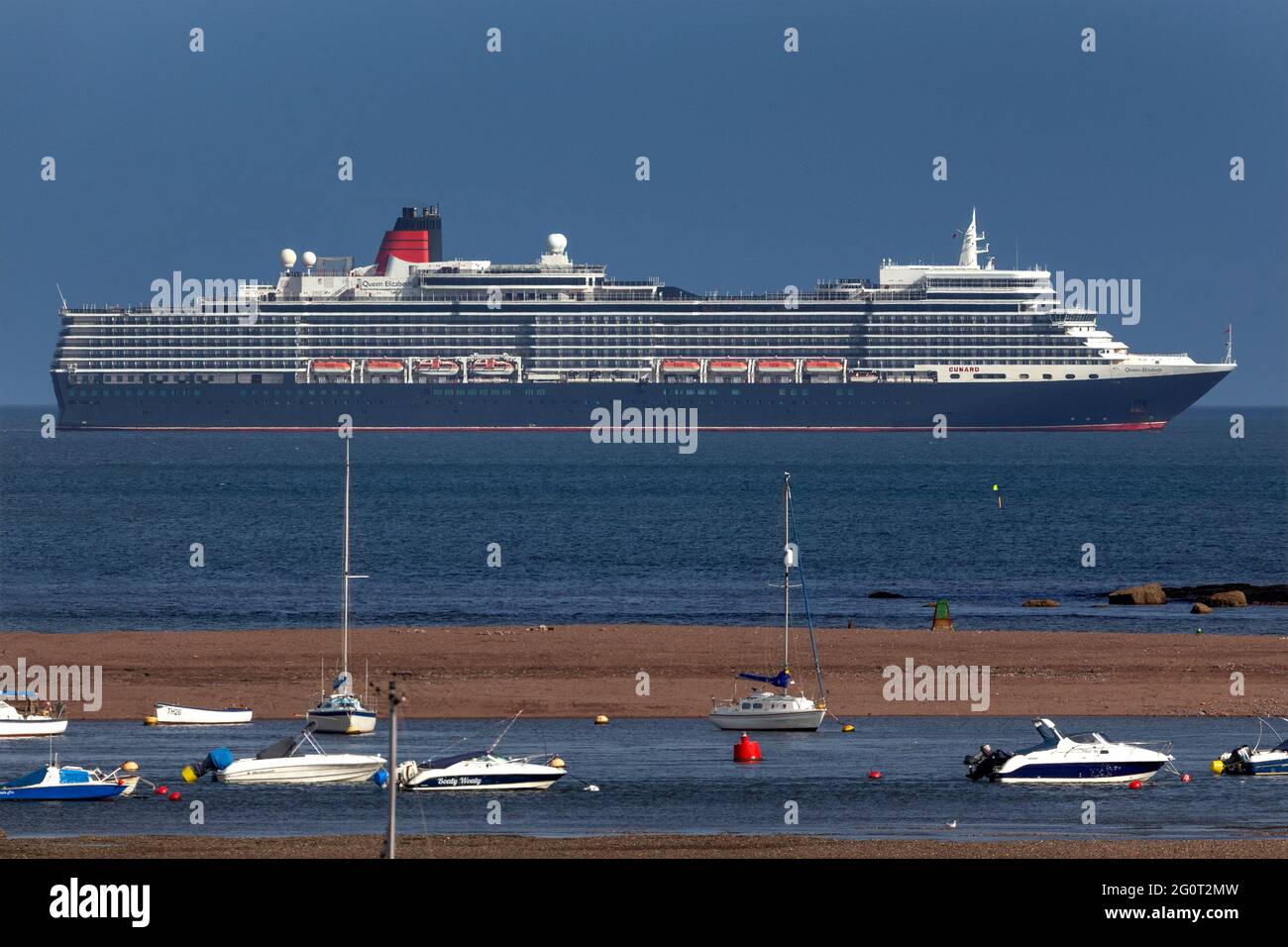 The Queen Elizabeth cruise ship basks in glorious sunshine off the coast of Teignmouth, Devon. Stock Photo