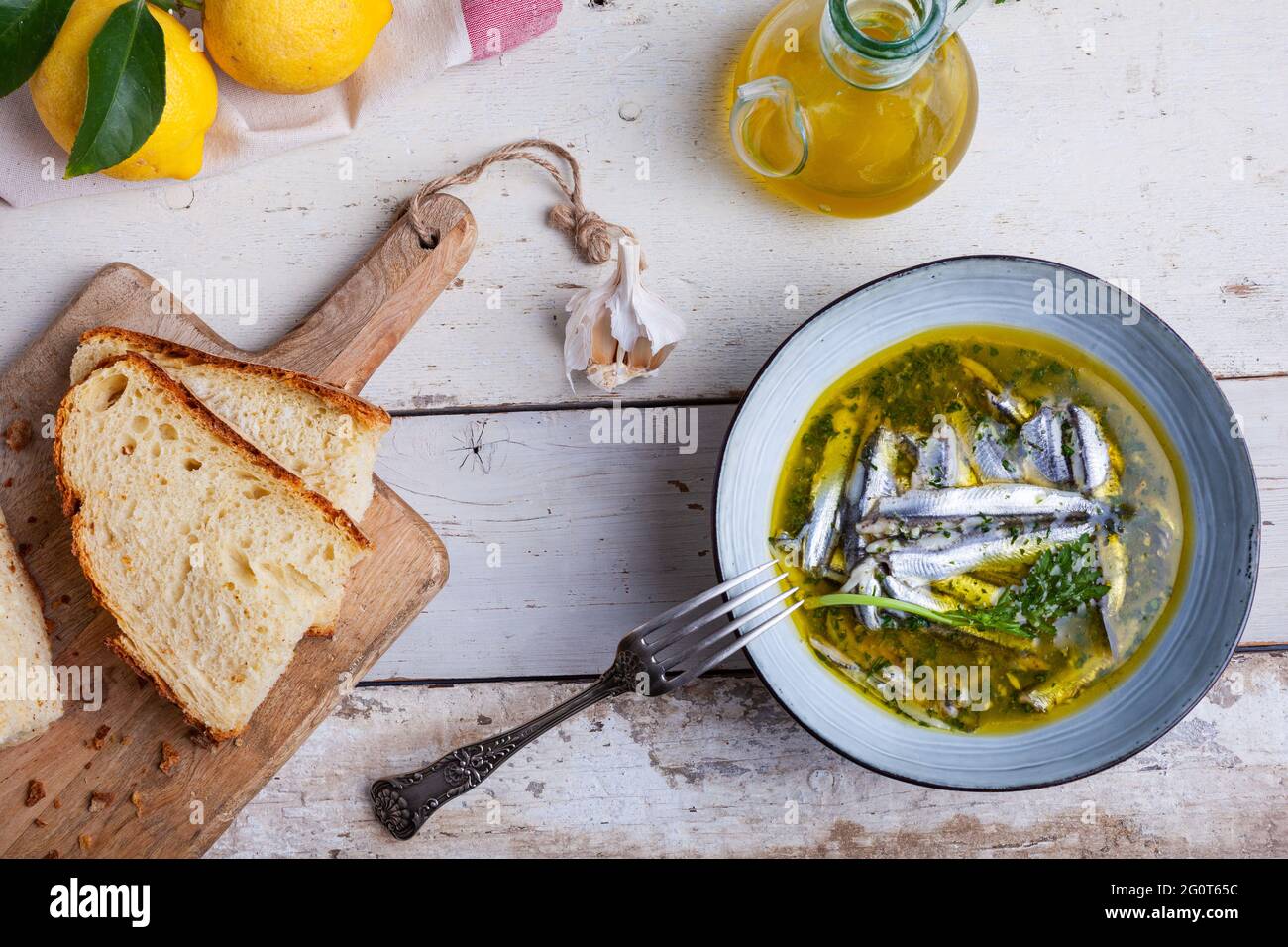 Flat lay of Marinated anchovies in lemon juice with olive oil garlic and parsley. Traditional