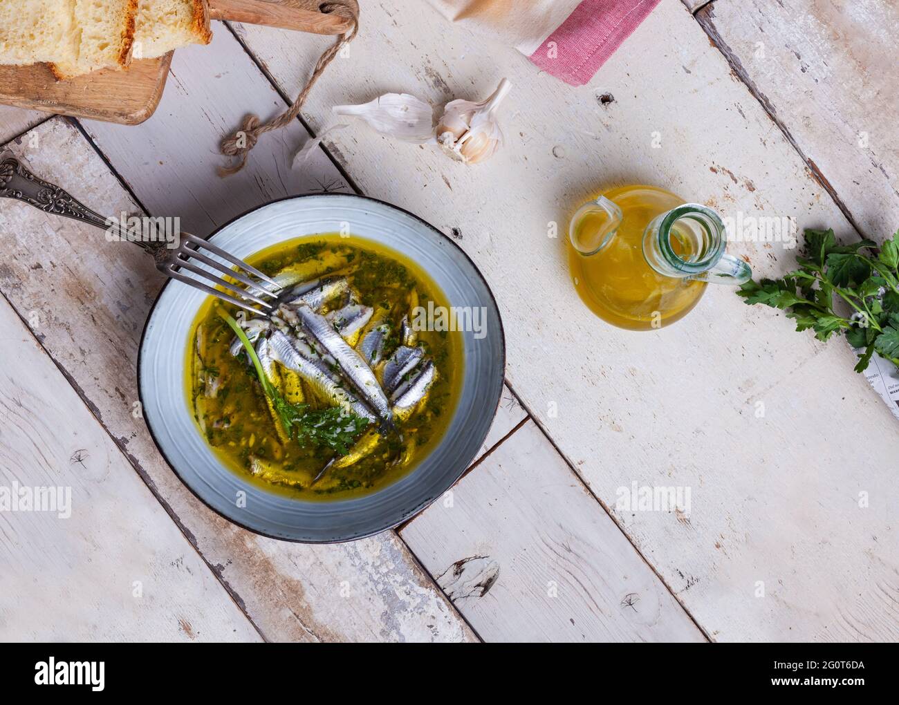 Flat lay of Marinated anchovies in lemon juice with olive oil garlic and parsley. Traditional
