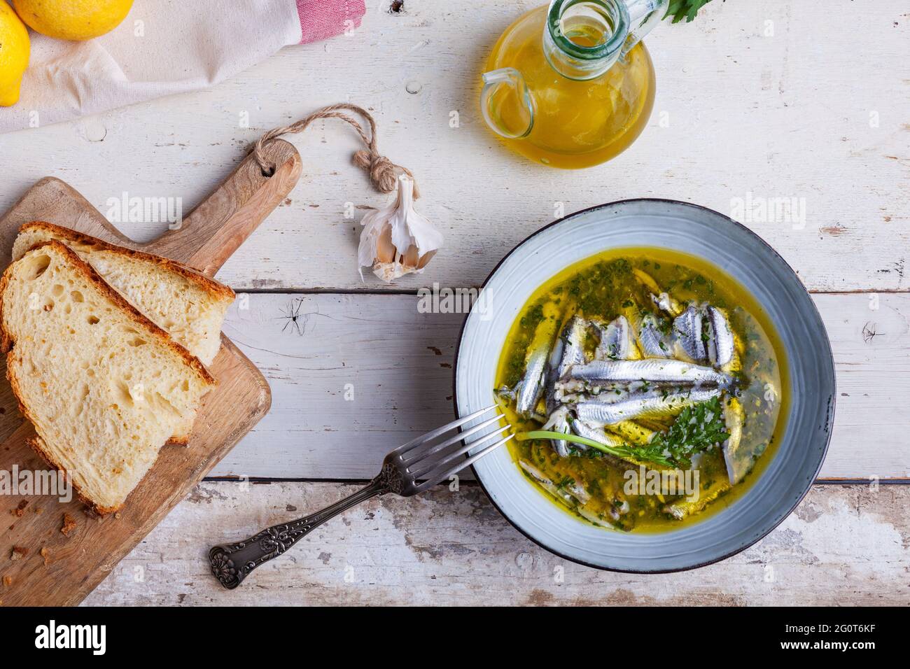 Flat lay of Marinated anchovies in lemon juice with olive oil garlic and parsley. Traditional