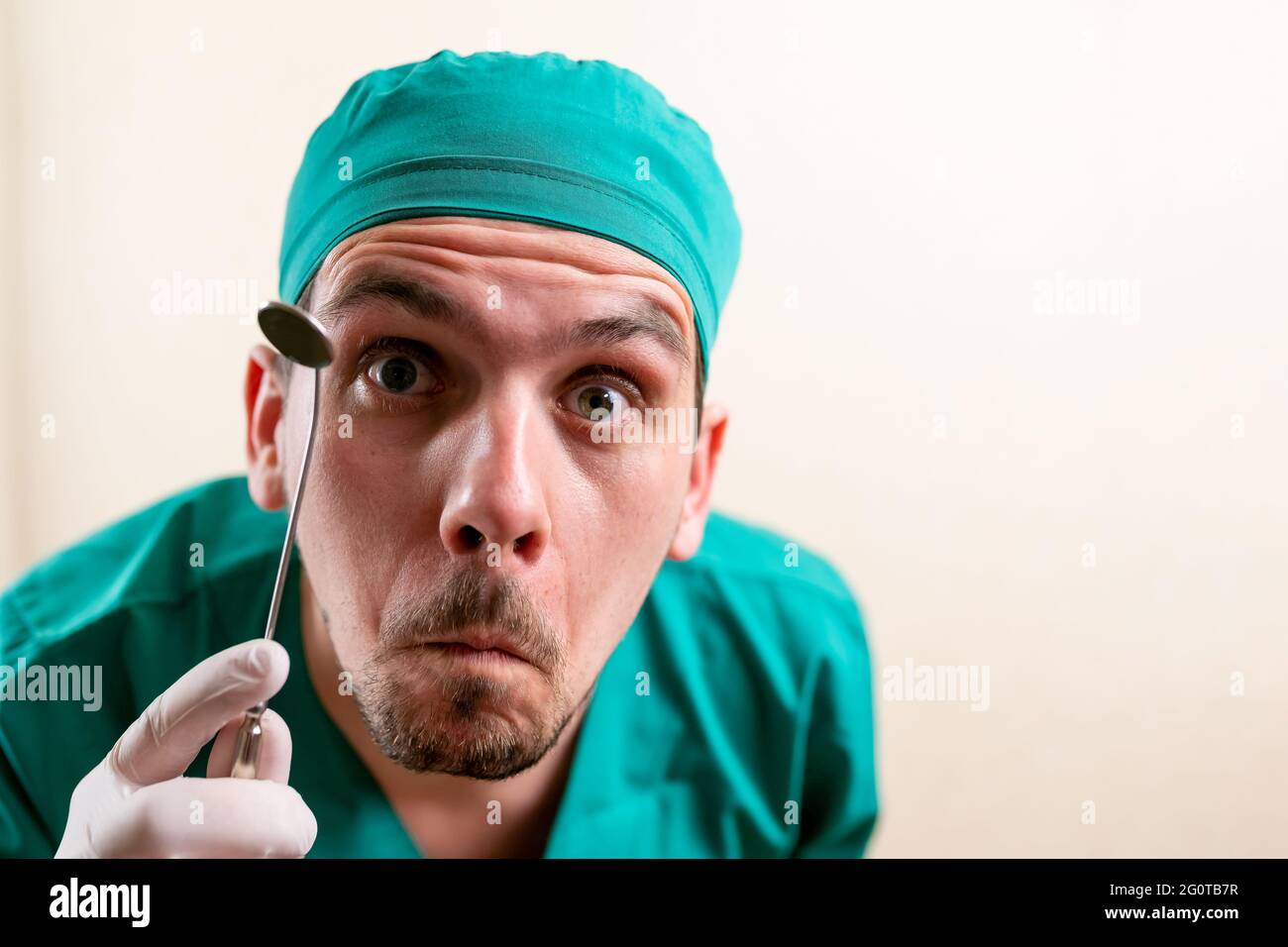 Doctor ENT, wearing a mask and glasses, with a device in his hands. Stock Photo