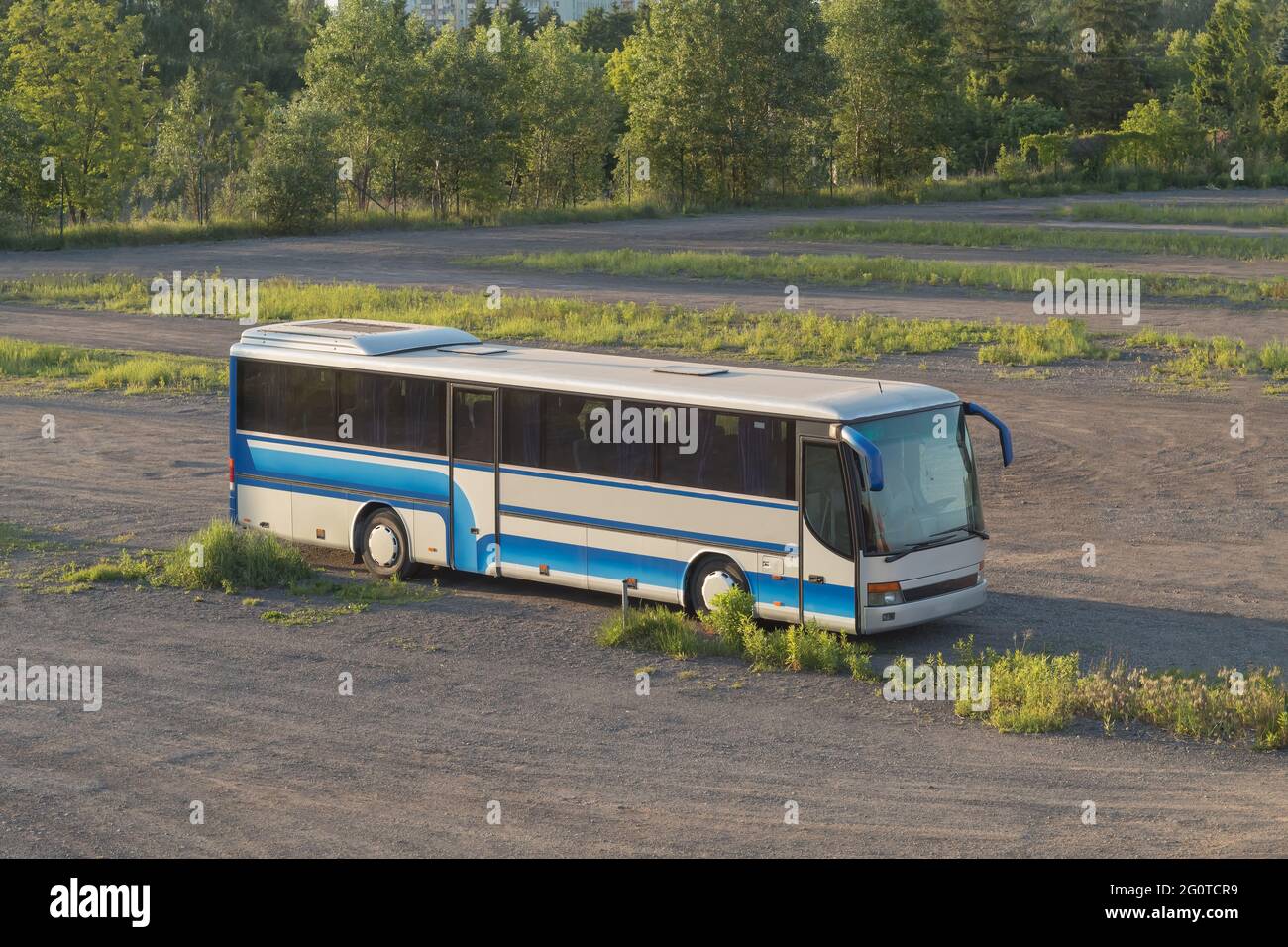 The bus stands in a field on a dirt road. Bus in the middle of the field. Background with place for text Stock Photo