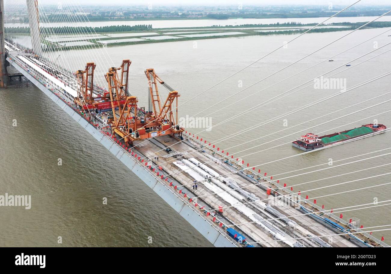 Wuhan, China. 3rd June, 2021. Aerial photo taken on June 3, 2021 shows the closure segment of Bianyuzhou Yangtze River Bridge on the border of central China's Hubei Province and east China's Jiangxi Province. Connecting Huangmei County of central China's Hubei Province and Jiujiang City of east China's Jiangxi Province, the bridge is part of Anqing-Jiujiang Railway. The railway has a designed speed of 350 kilometers per hour for the two high speed lines and 200 kilometers per hour for the other two reserved passenger and freight lines. Credit: Cheng Min/Xinhua/Alamy Live News Stock Photo