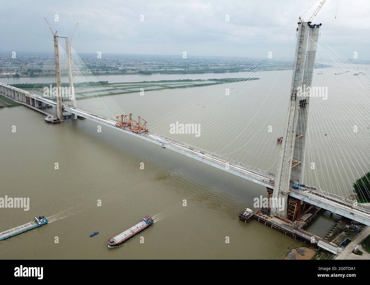 (210603) -- WUHAN, June 3, 2021 (Xinhua) -- Aerial photo taken on June 3, 2021 shows the Bianyuzhou Yangtze River Bridge on the border of central China's Hubei Province and east China's Jiangxi Province. Connecting Huangmei County of central China's Hubei Province and Jiujiang City of east China's Jiangxi Province, the bridge is part of Anqing-Jiujiang Railway. The railway has a designed speed of 350 kilometers per hour for the two high speed lines and 200 kilometers per hour for the other two reserved passenger and freight lines. (Xinhua/Cheng Min) Stock Photo