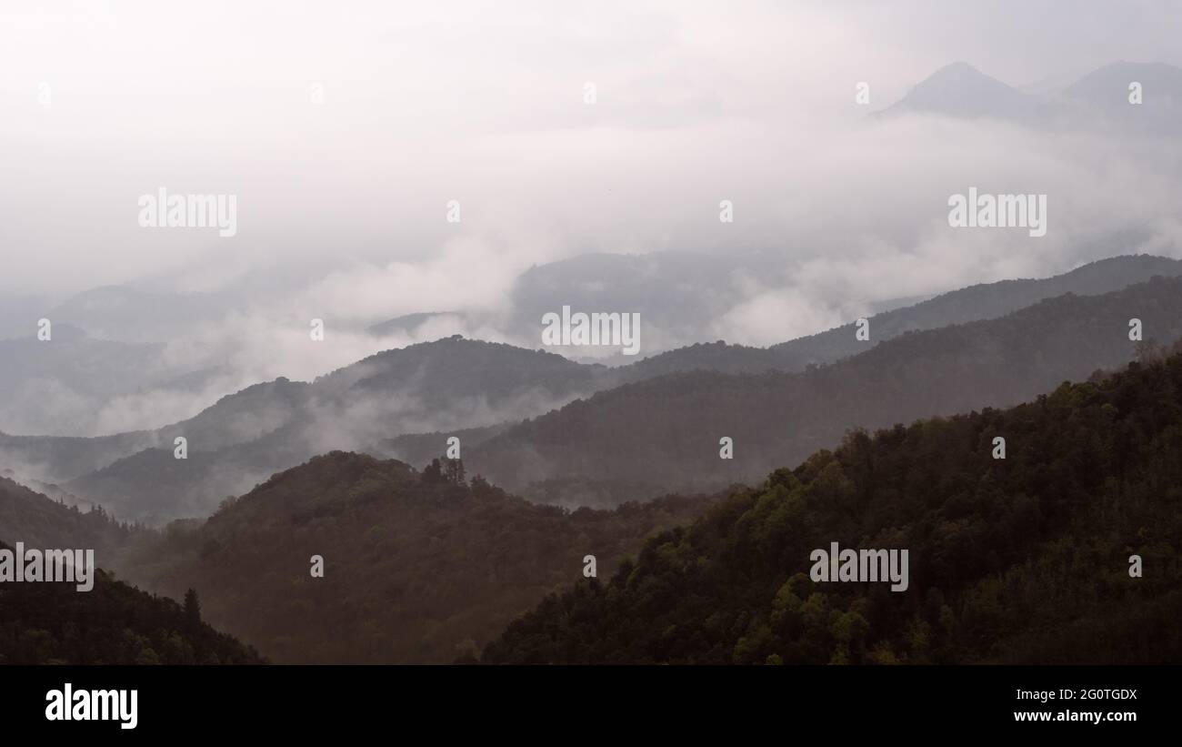 Cloudy and foggy mountain landscape from the top of a hill Stock Photo ...