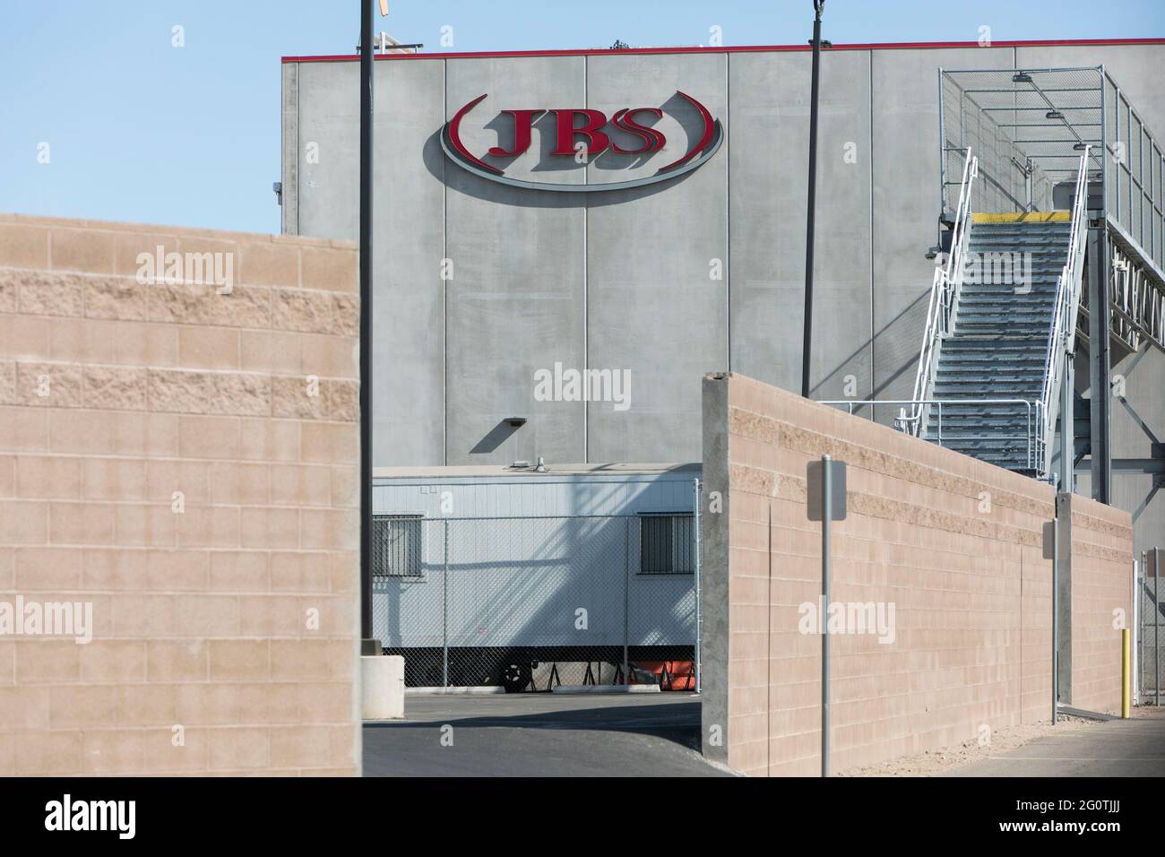 A logo sign outside of a facility occupied by JBS USA in Tolleson