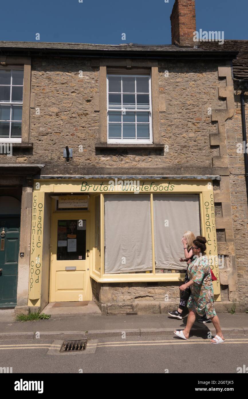 women walking past wholefood shop window in Bruton high Street
