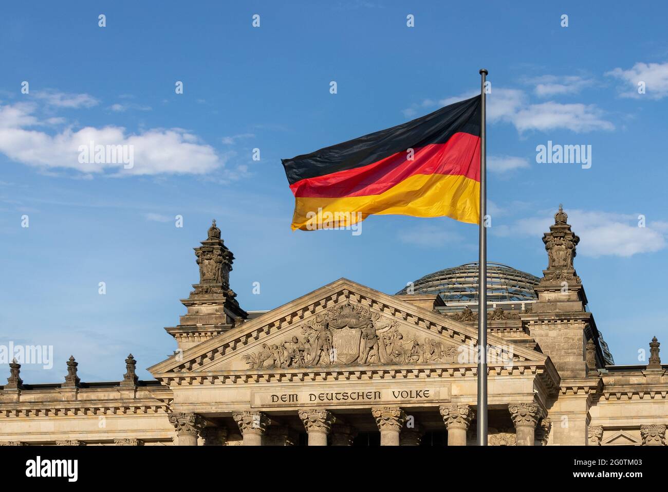 German Flag in front of the German Parliament (Bundestag) - Reichstag Building - Berlin, Germany - Text says: To the German People Stock Photo