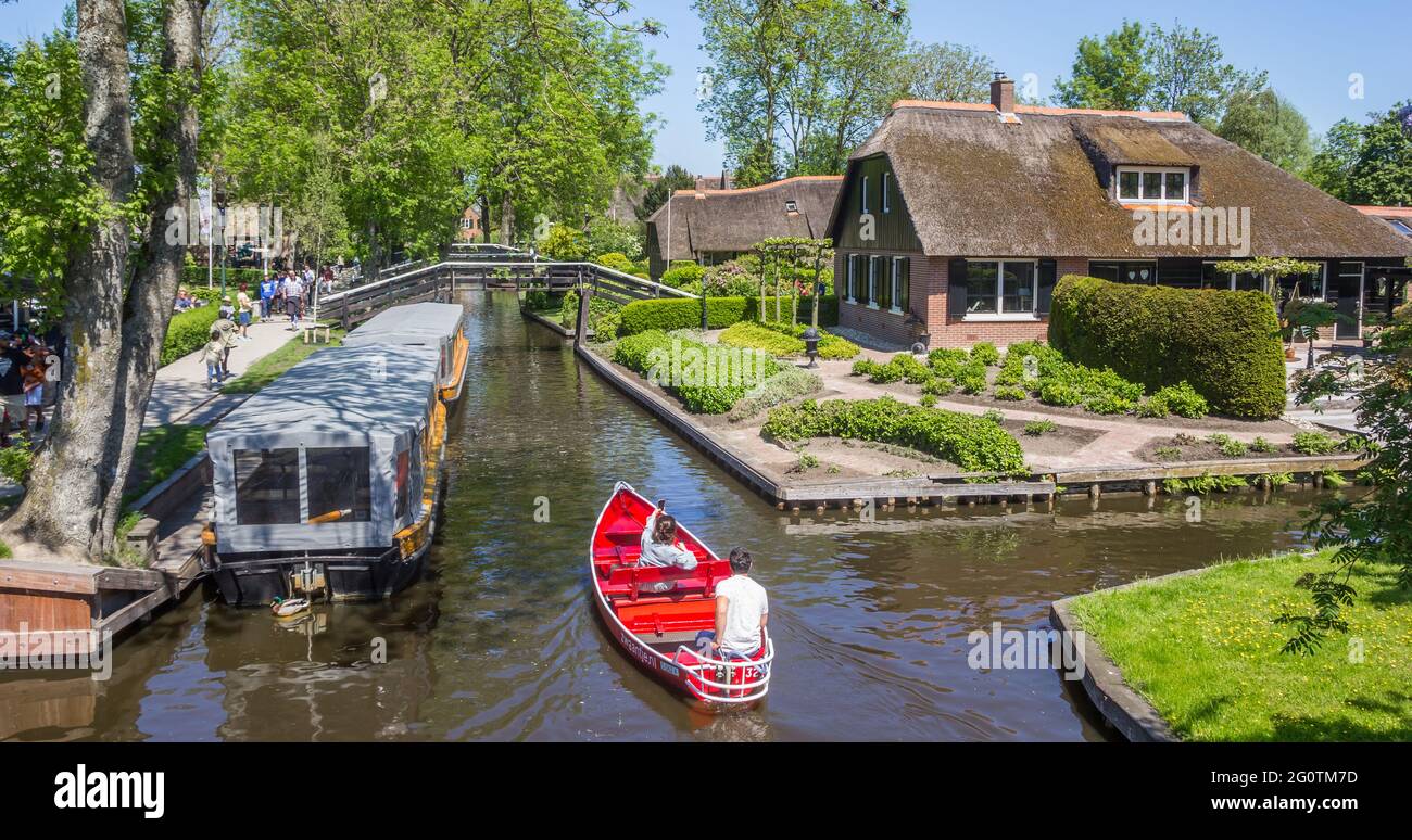 Couple enjoying the histori architecture in a red boat in Giethoorn, Netherlands Stock Photo