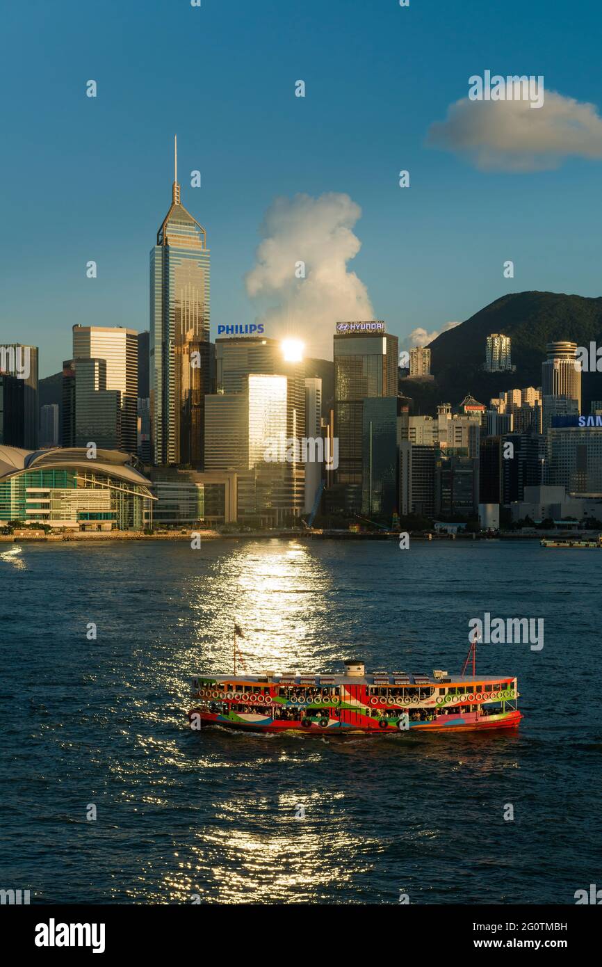 An iconic Star Ferry passes through the reflection of the late