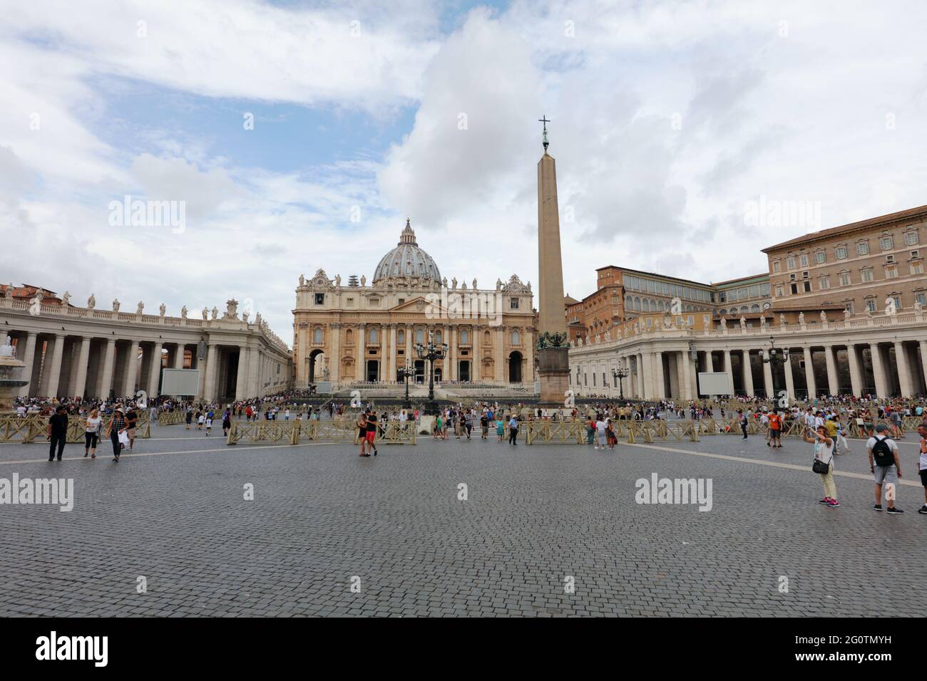 People on St. Peter's square in Vatican against St. Peter basilica, the most renowned work of Renaissance architecture and largest church in the world Stock Photo