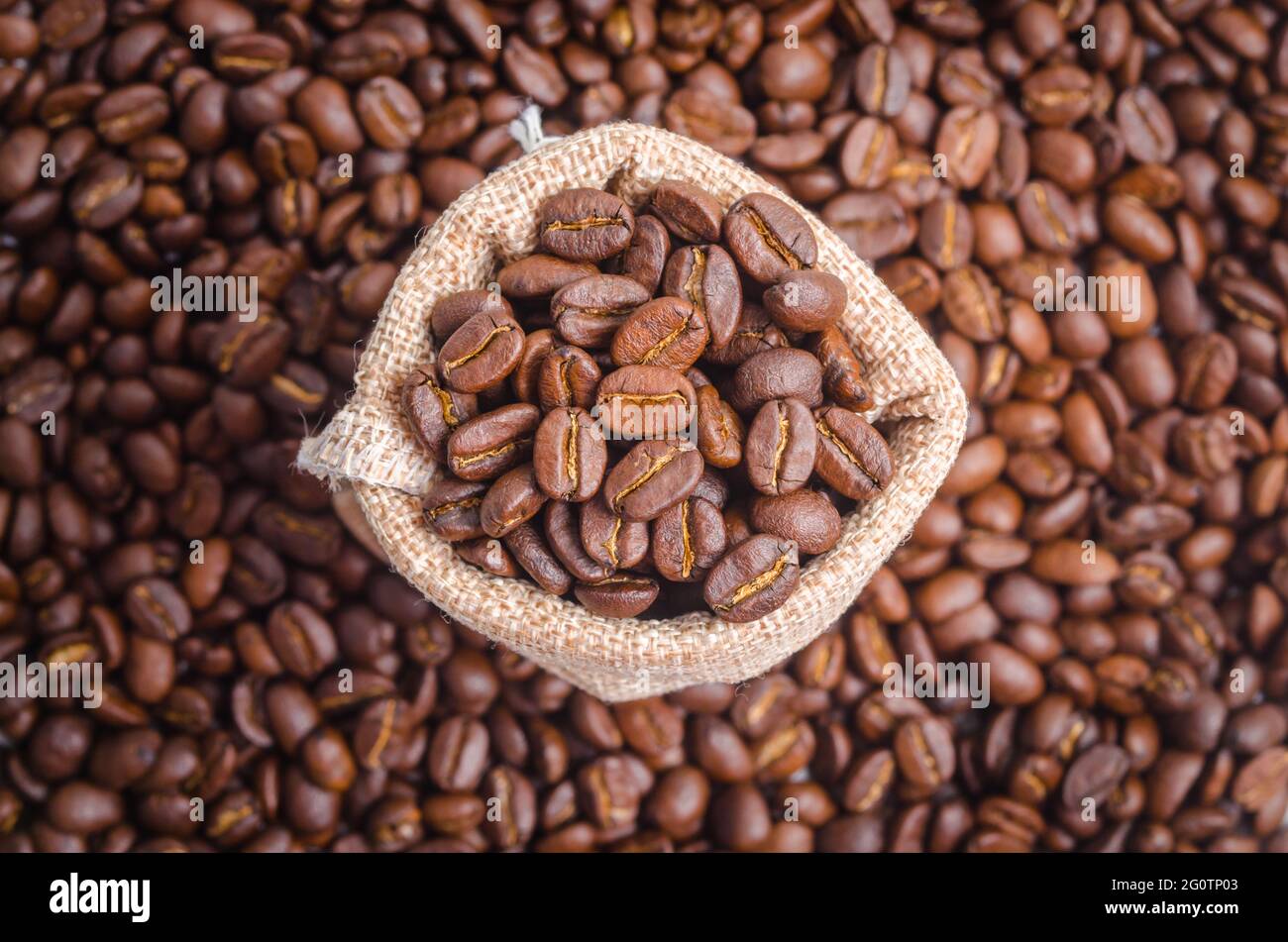 Coffee beans in sack bag on coffee beans background Stock Photo - Alamy