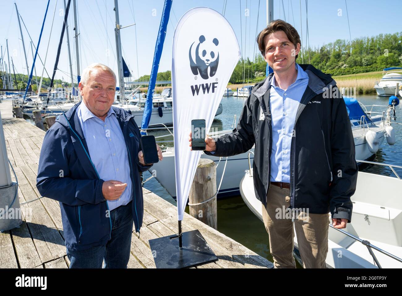 Seedorf, Germany. 03rd June, 2021. Till Backhaus (l, SPD), Minister of Agriculture and Environment of Mecklenburg-Western Pomerania, and Florian Hoffmann, biologist from WWF, present the new navigation app for better protection of marine protected areas. In the future, the app will enable anglers and recreational boaters to navigate through the waters south of Rügen in a way that complies with the law and protects animals. The WWF commissioned the app together with the State Office for Agriculture and the Environment of Western Pomerania. Credit: Stefan Sauer/dpa/Alamy Live News Stock Photo
