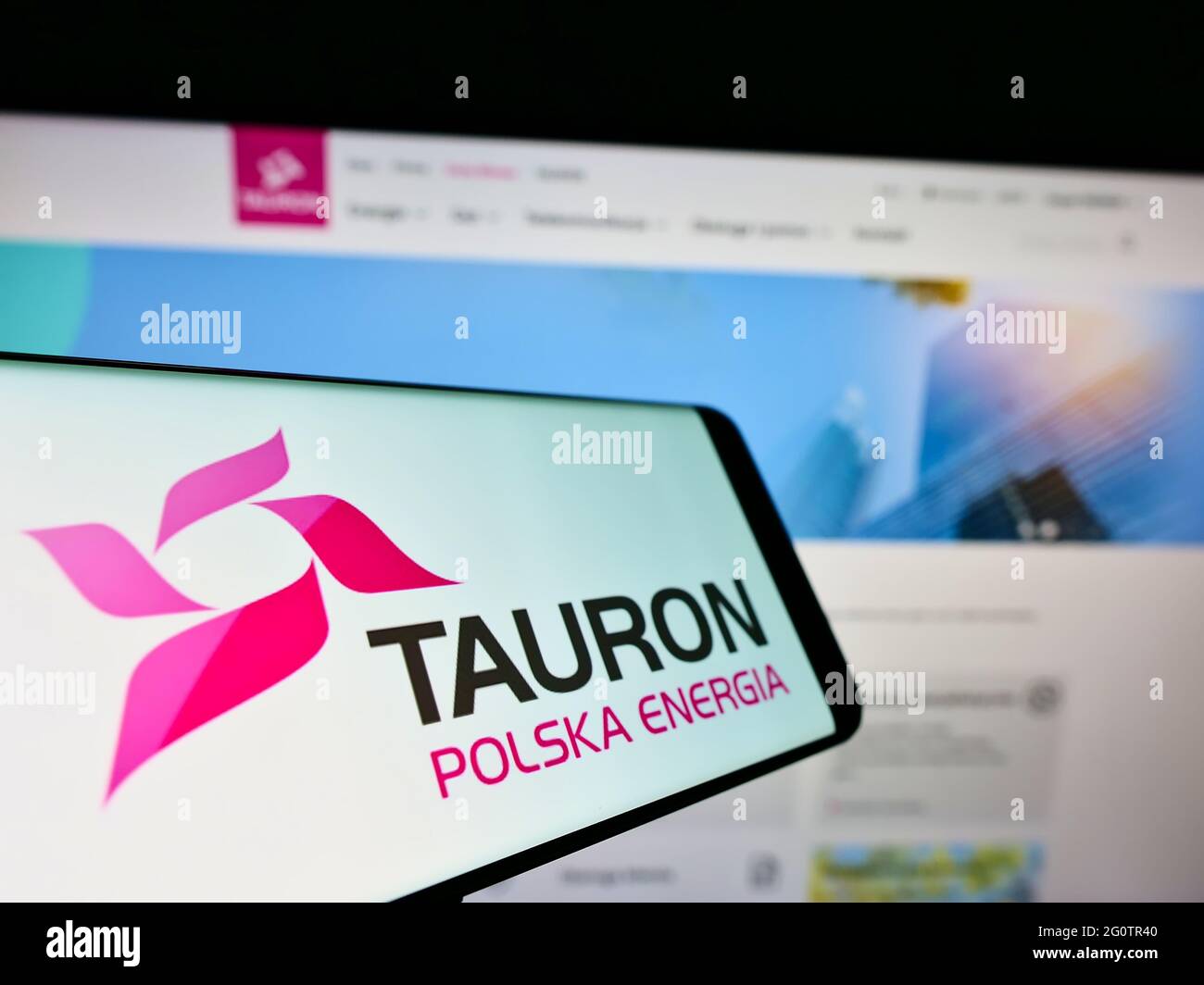 Mobile phone with logo of Polish energy company Tauron Polska Energia S.A. on screen in front of website. Focus on center-right of phone display. Stock Photo