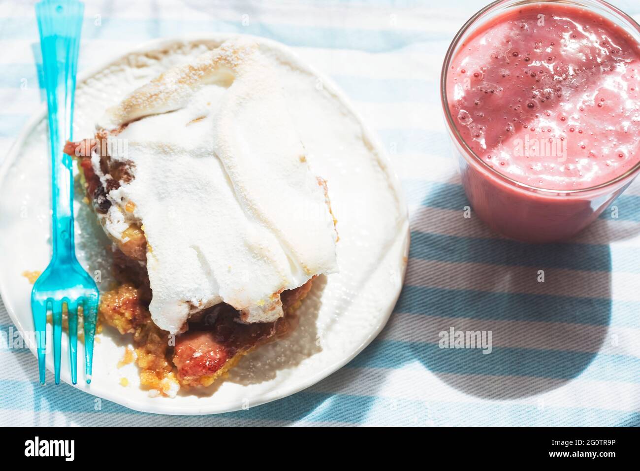 Rhubarb shortcrust cake with meringue on top with strawberry smoothie Stock Photo