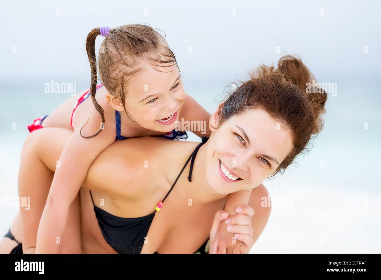 Happy mother and little daughter having fun on sand beach on Maldives at summer vacation. Family on the beach concept. Stock Photo