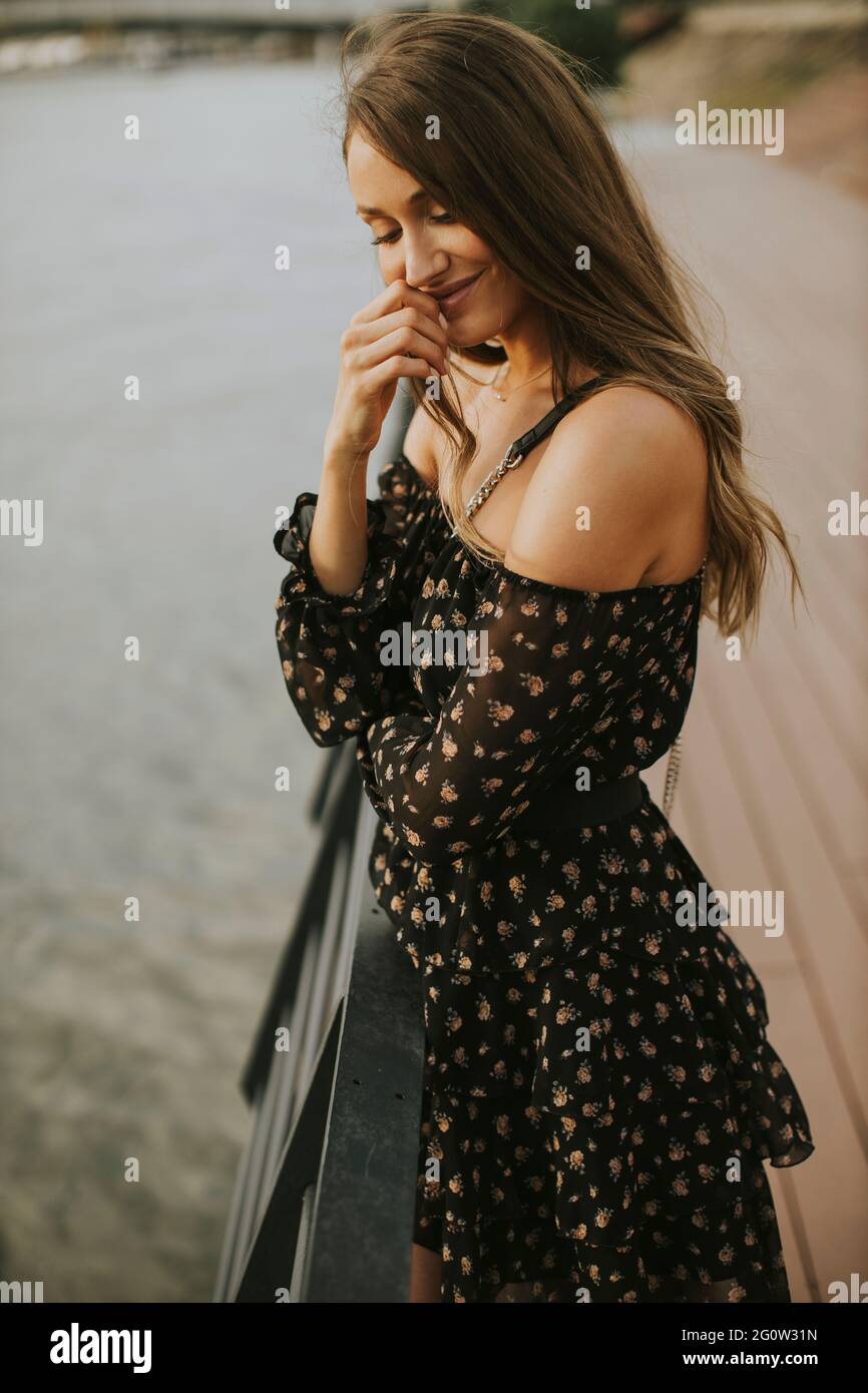 Pretty young long hair brunette woman standing on the riverside Stock ...