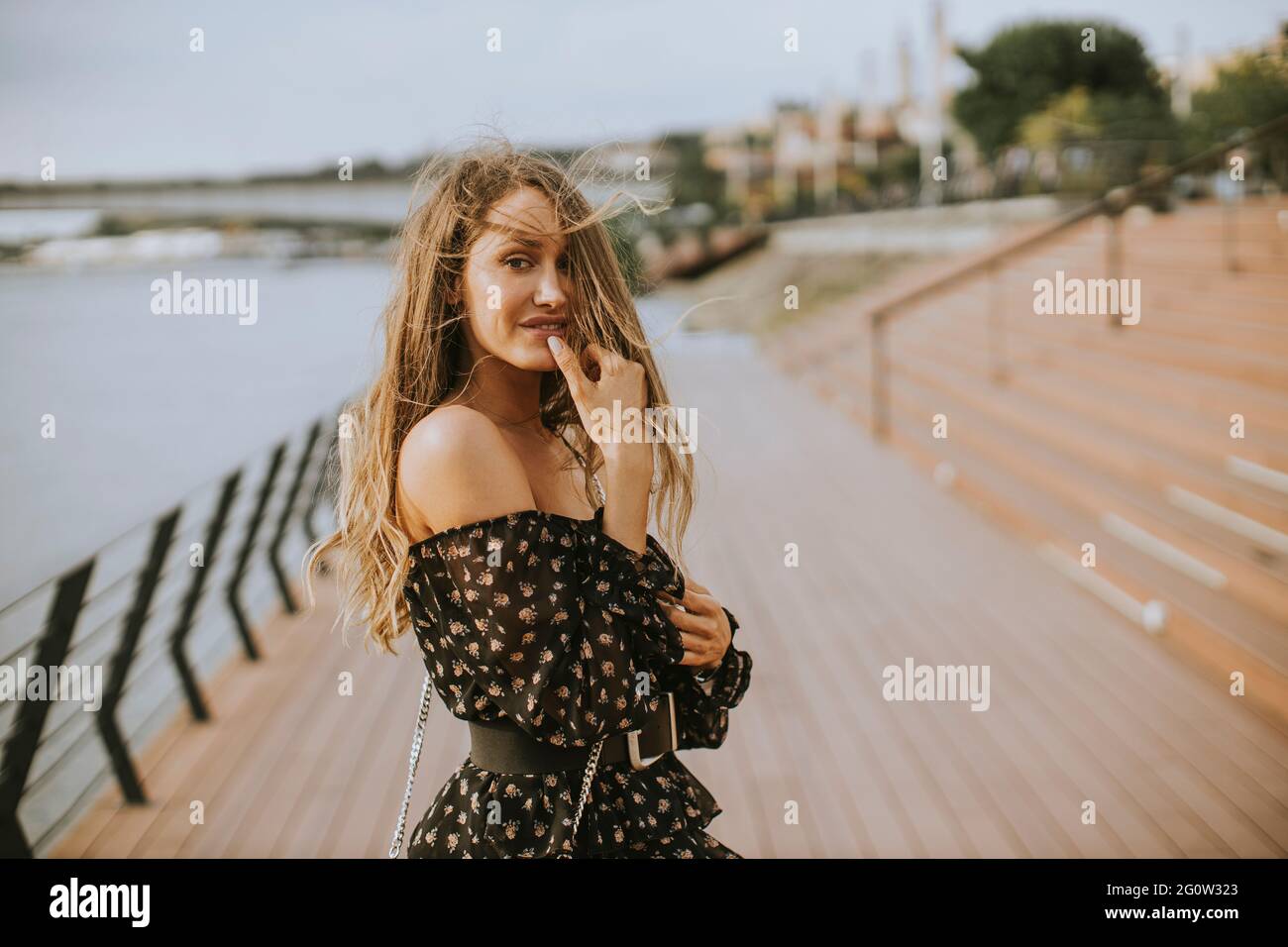 Pretty young long hair brunette woman walking on the riverside Stock ...