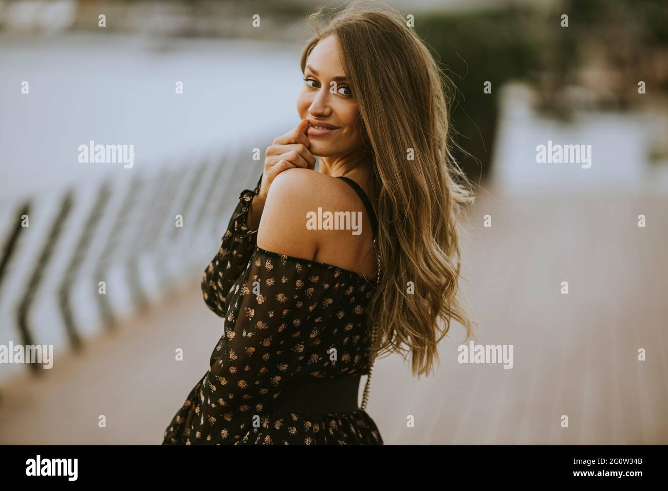 Pretty young long hair brunette woman walking on the riverside Stock ...