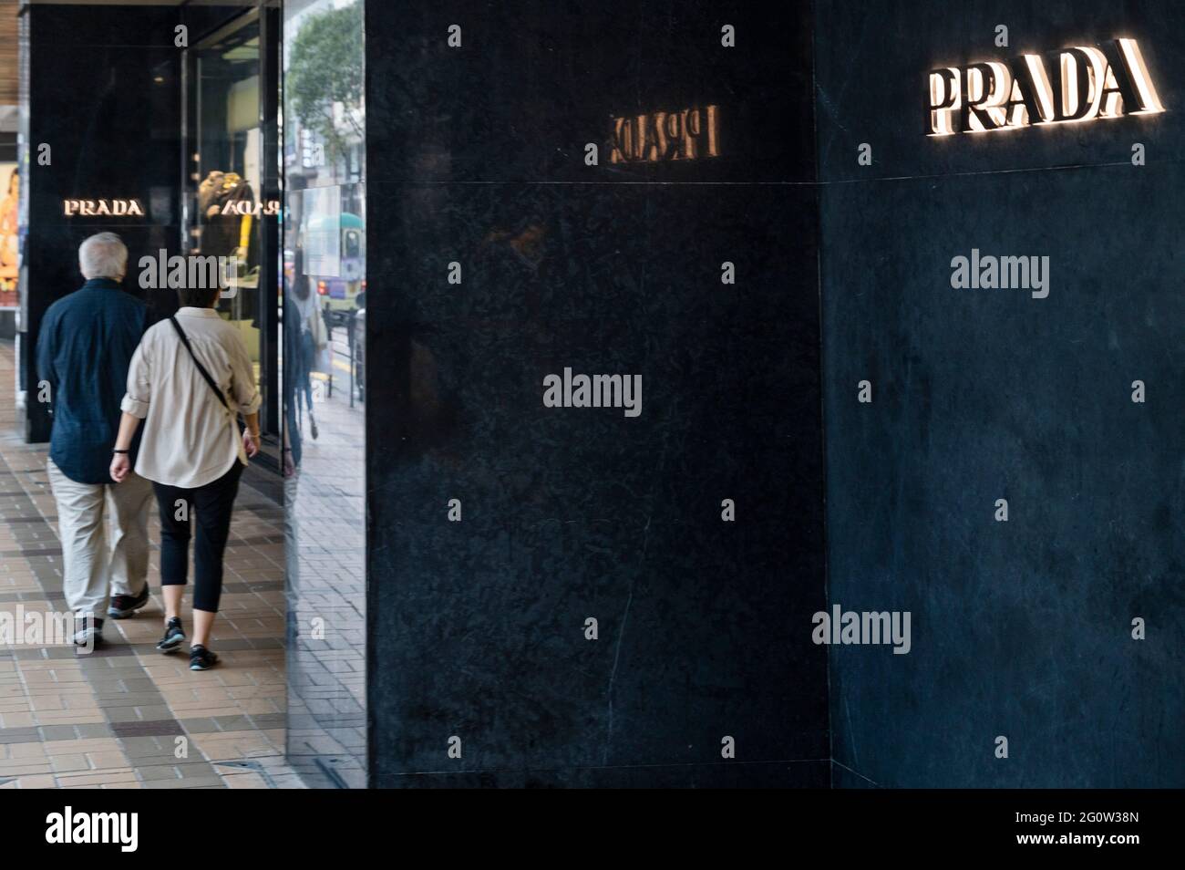 Hong Kong, China. 03rd June, 2021. A couple walks past the Italian luxury  fashion company Prada logo and store seen in Hong Kong. (Photo by Budrul  Chukrut/SOPA Images/Sipa USA) Credit: Sipa USA/Alamy