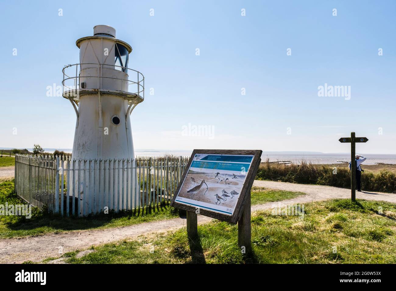 East Usk Lighthouse by Coastal Path and information board for Severn estuary at Newport Wetlands National Nature Reserve. Nash Newport Gwent Wales UK Stock Photo
