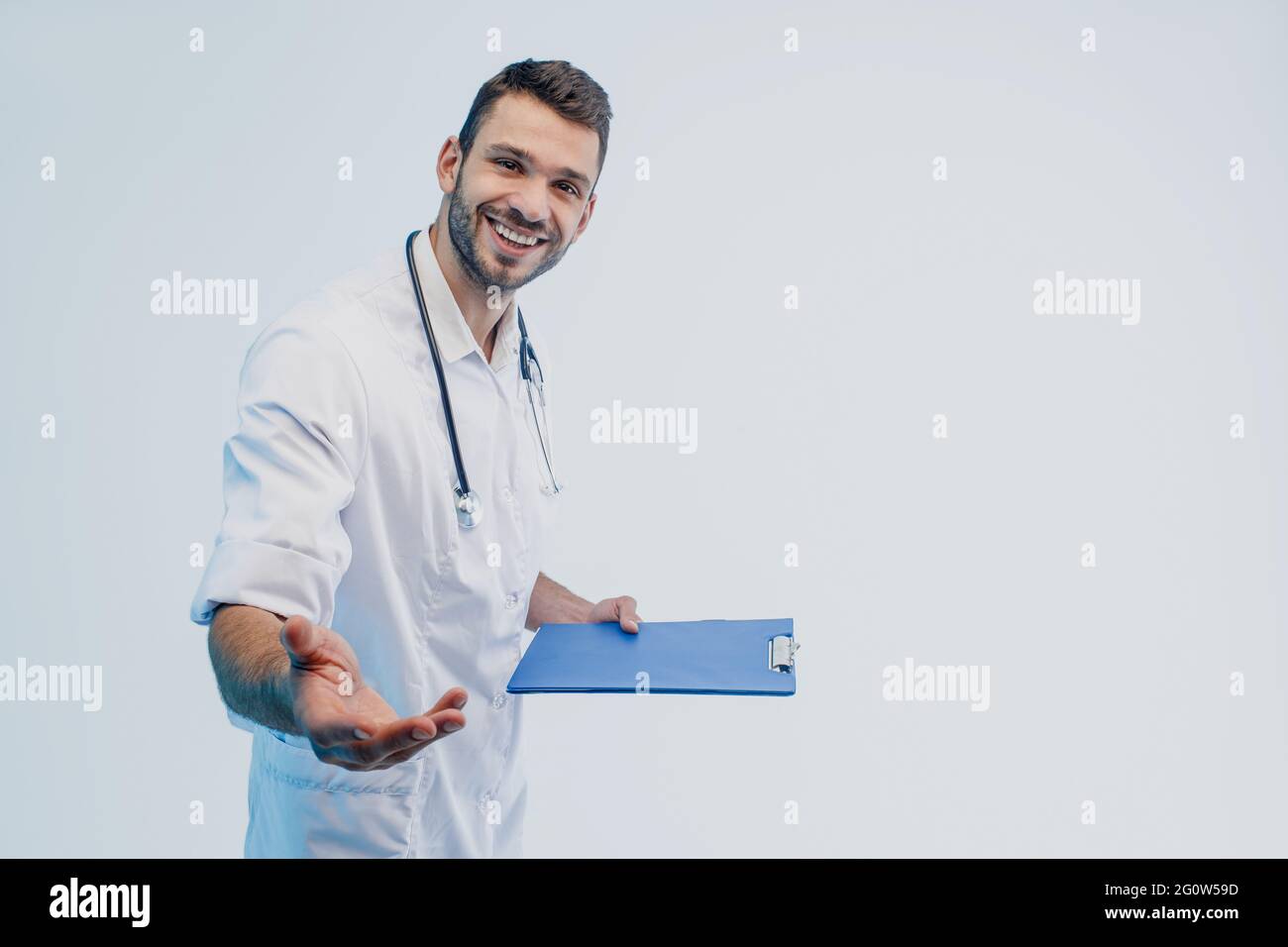 Smiling young european male doctor hold clipboard Stock Photo