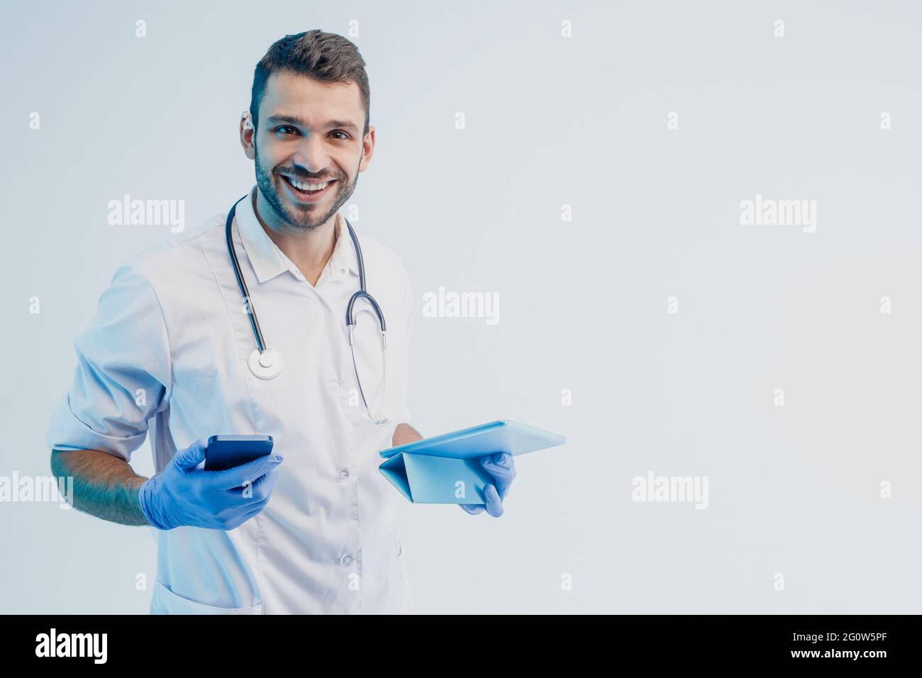 Male doctor with mobile phone and digital tablet Stock Photo
