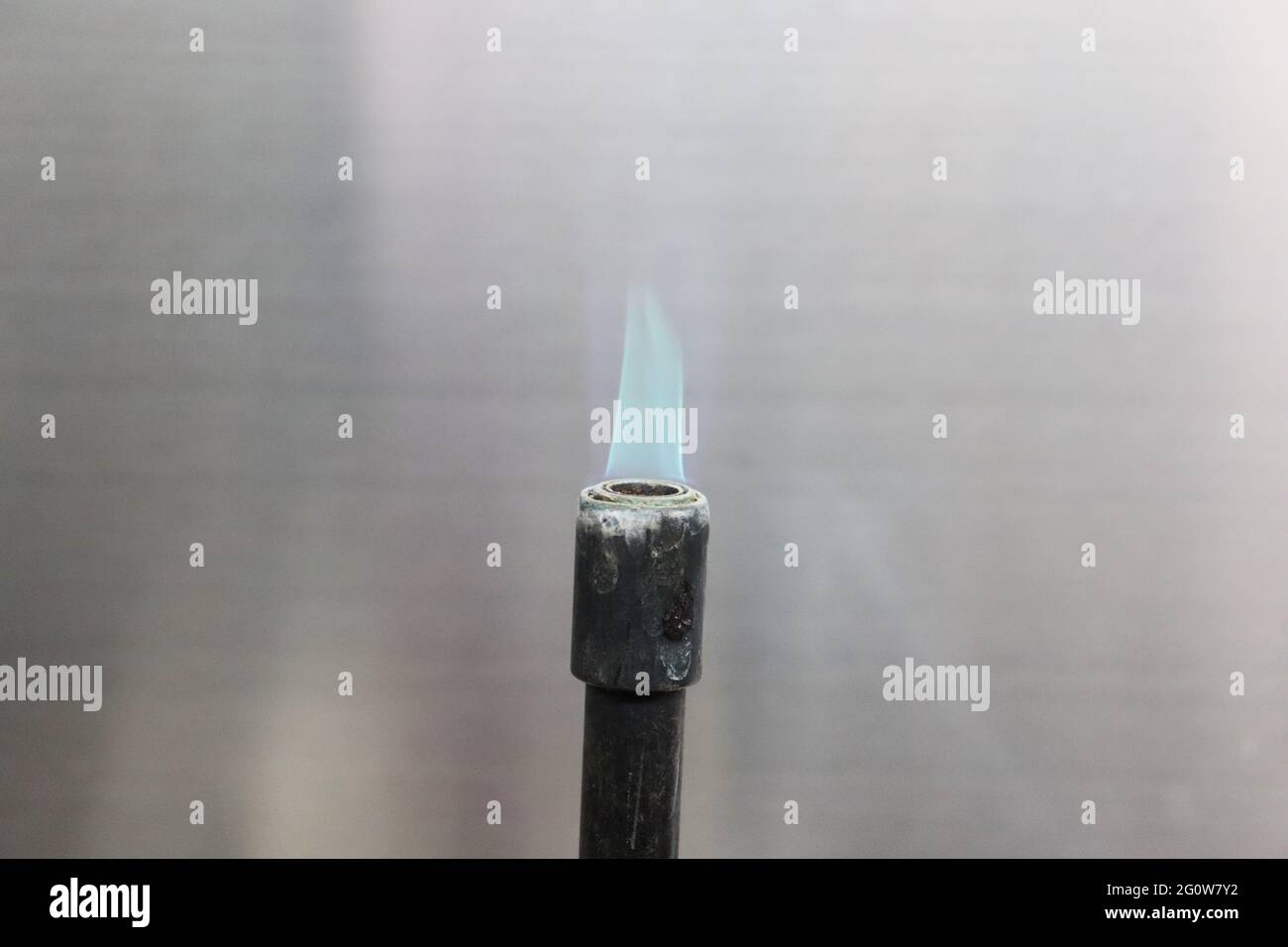 A Bunsen burner, named after Robert Bunsen, is a kind of gas burner used as laboratory equipment; it produces a single open gas flame Stock Photo