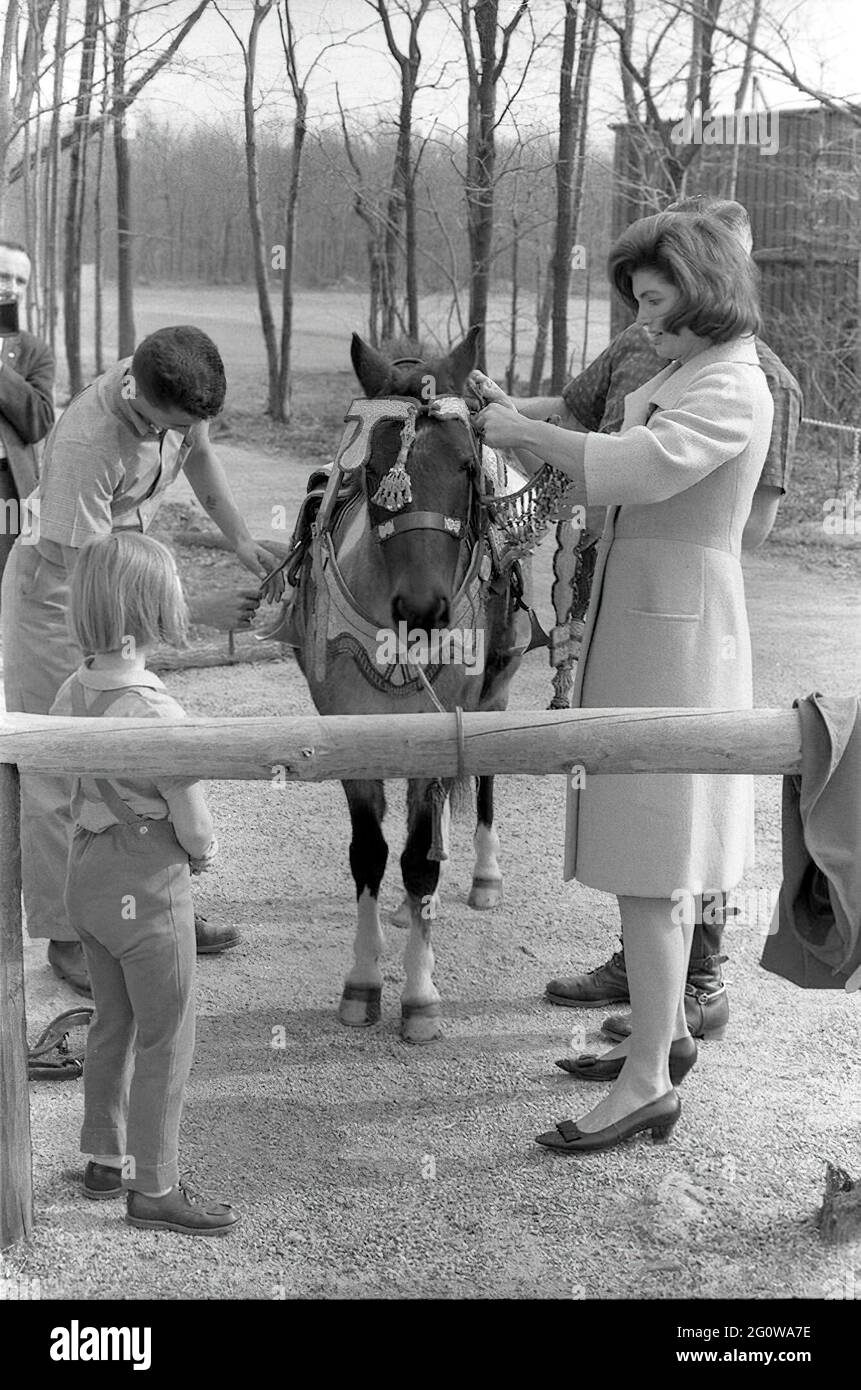 KN-27627              31 March 1963  Weekend at Camp David. First Lady Jacqueline B. Kennedy with daughter Caroline and others with 'Macaroni' in a Moroccan saddle, a gift of King Hassan II, during a weekend at Camp David.    Please credit 'Robert Knudsen. White House Photographs. John F. Kennedy Presidential Library and Museum, Boston' Stock Photo