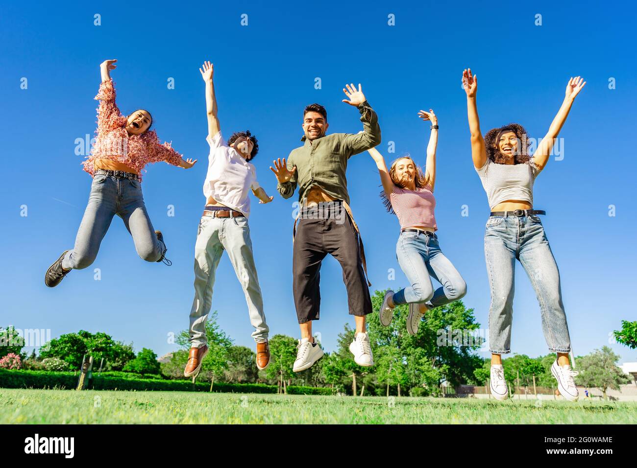 Group of happy young diverse multiracial gen z friends jumping together ...
