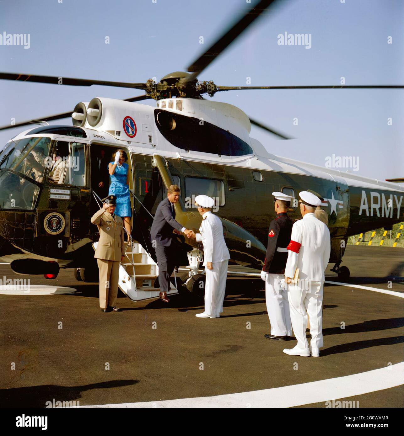 2 July 1963  President John F. Kennedy greets Admiral J.S. Russell as he departs a helicopter. Jean Smith exits the helicopter behind President Kennedy. North Atlantic Treaty Organization (NATO), Naples, Italy. Stock Photo