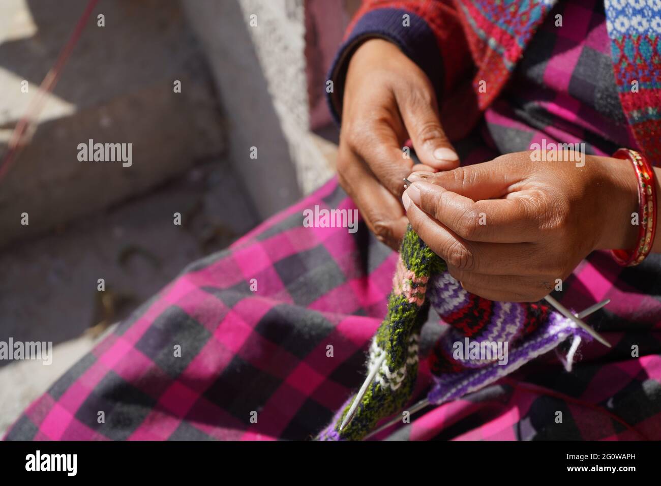 Closeup shot of the hands of a women sewing woolens Stock Photo