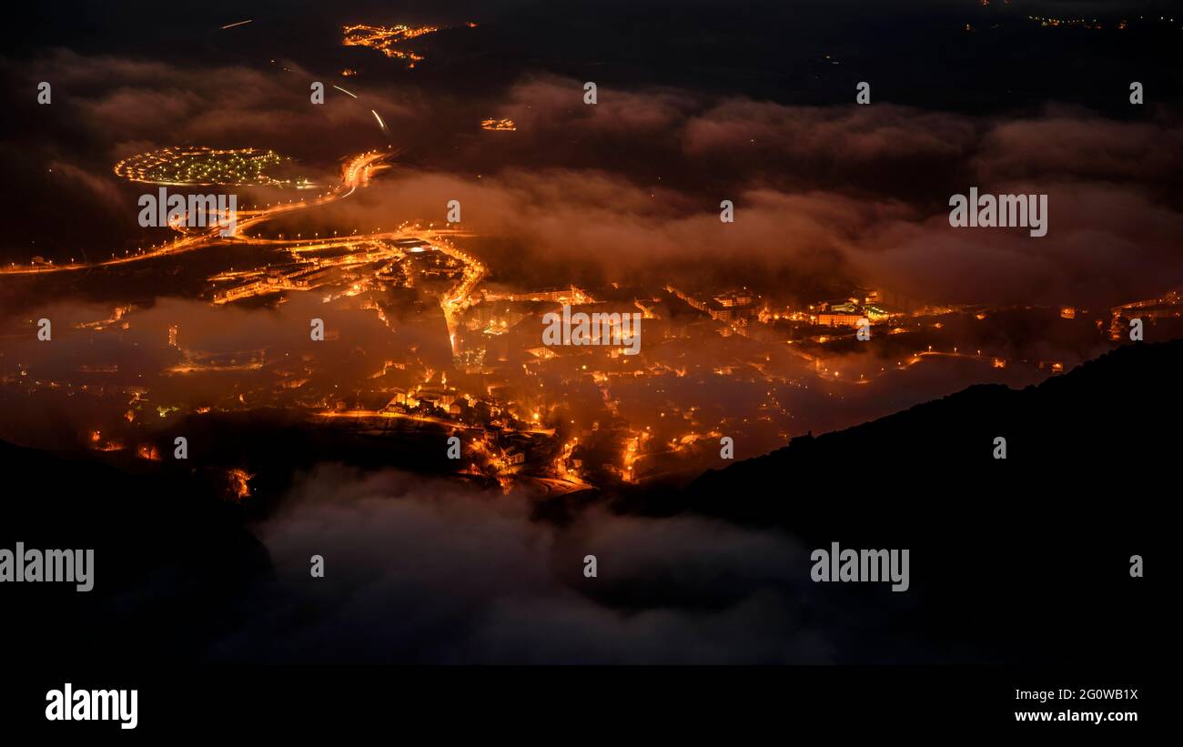 Fog over Berga city at night, seen from the Figuerassa viewpoint (Berguedà, Catalonia, Spain, Pyrenees) Stock Photo