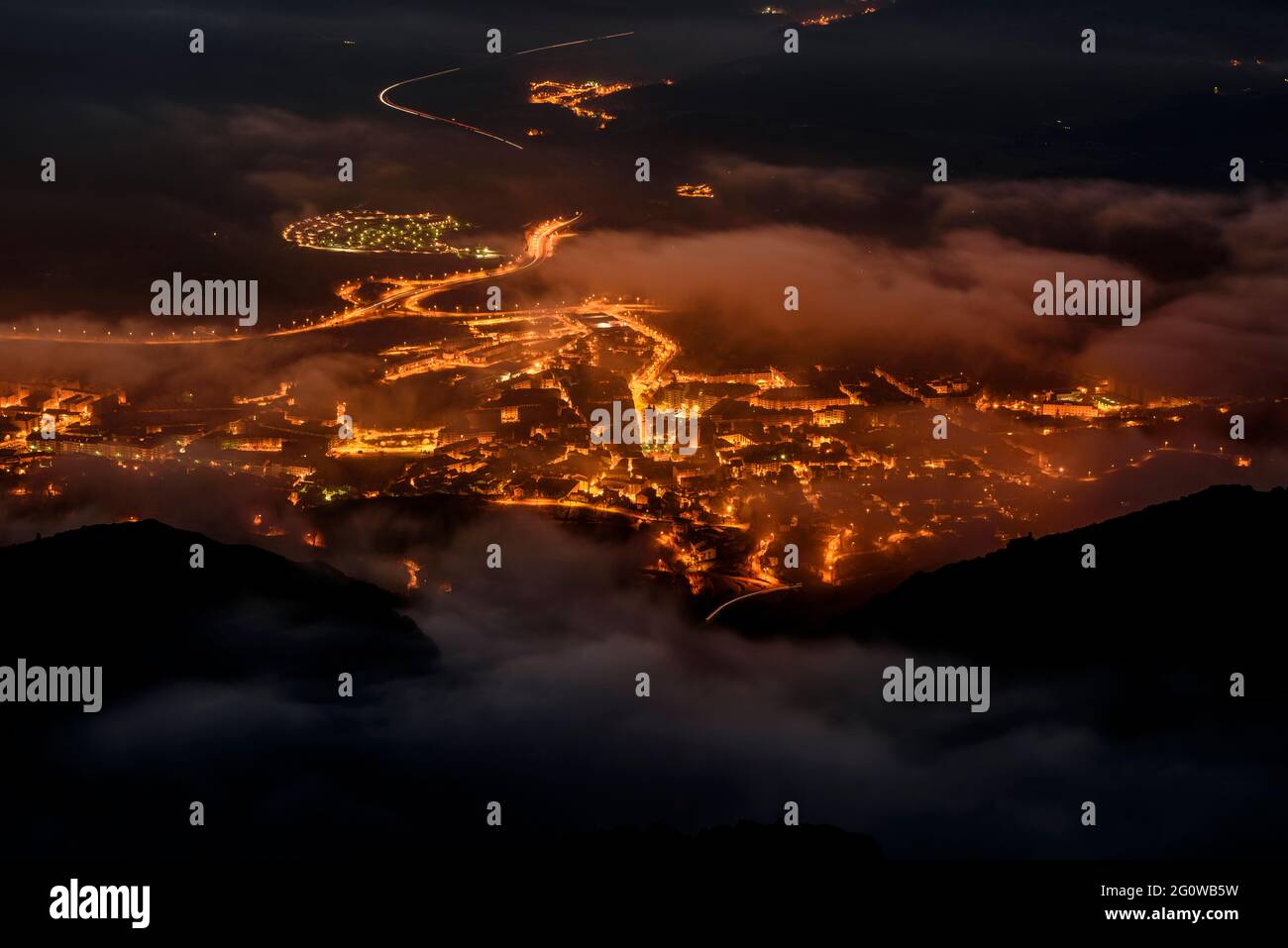 Fog over Berga city at night, seen from the Figuerassa viewpoint (Berguedà, Catalonia, Spain, Pyrenees) Stock Photo