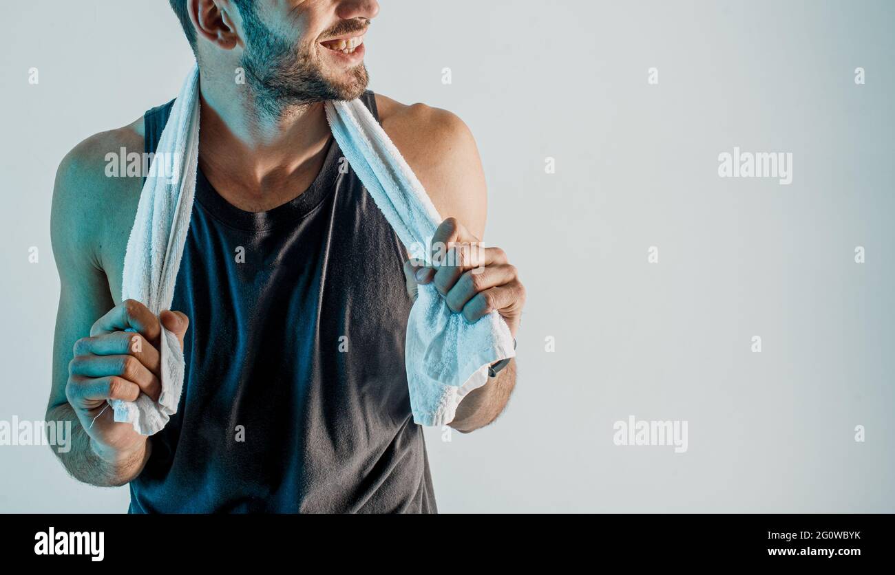 Smiling young sportsman with towel in studio Stock Photo