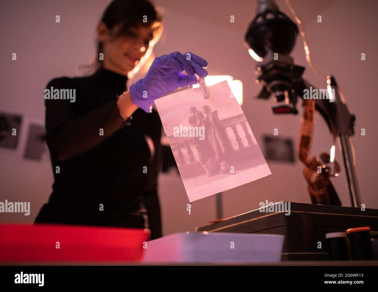 Female photographer developing film and printing photographs in