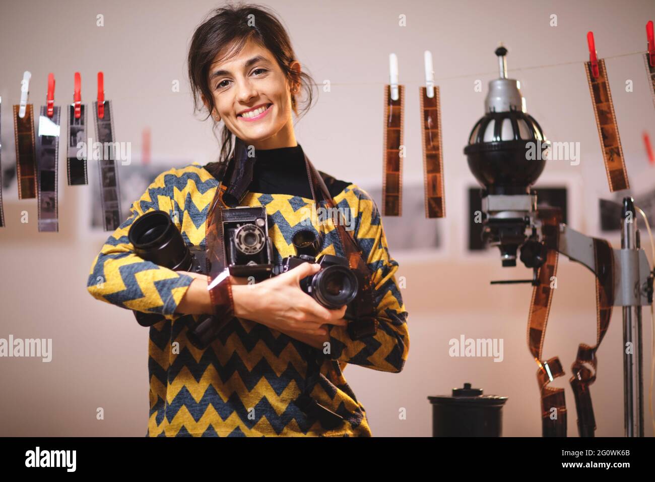 Portrait of beautiful female holding photo cameras in in photo studio Stock Photo