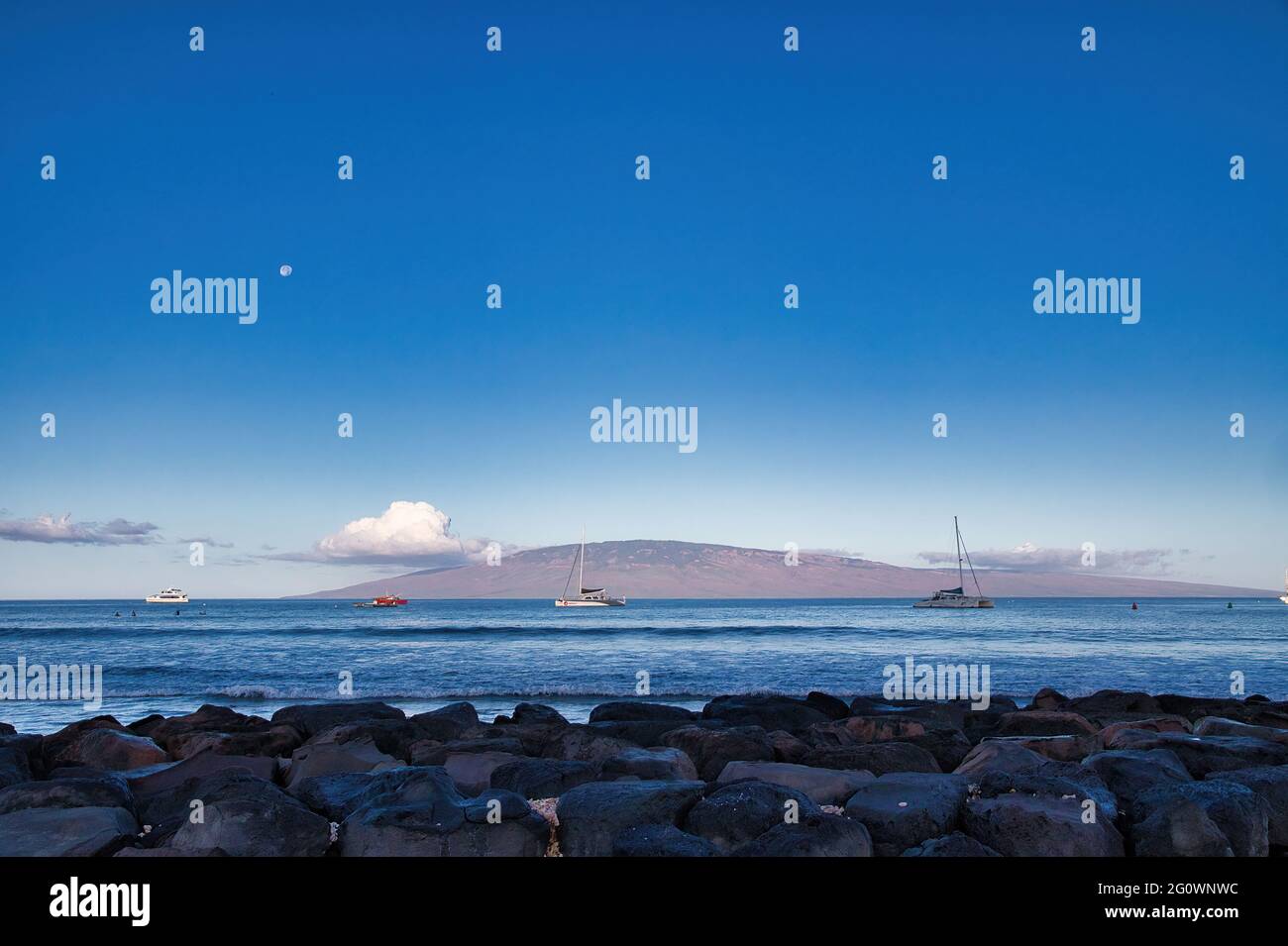 View of Lanai from Lanai harbor at dawn with moon set. Stock Photo