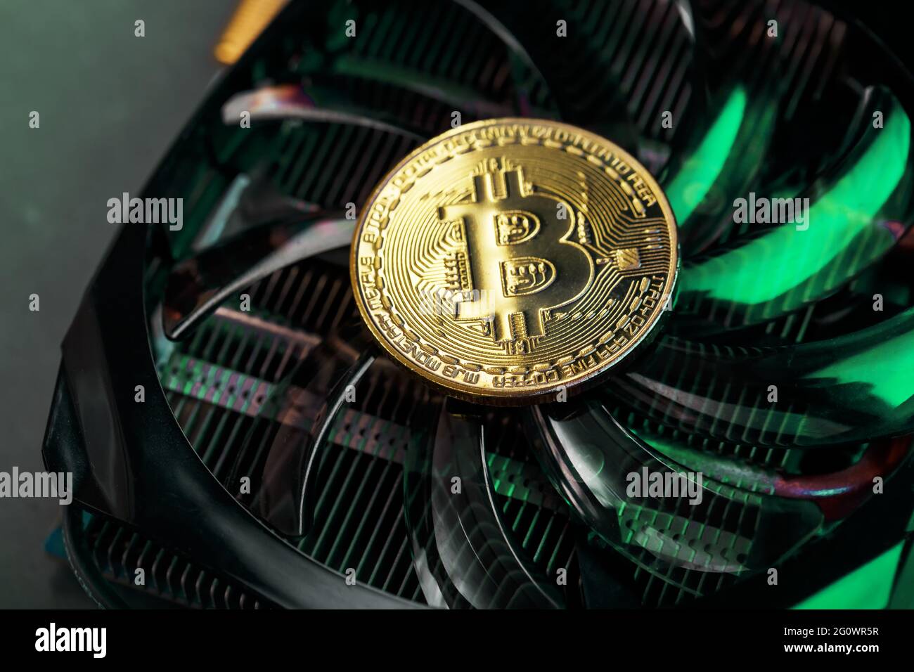 Gold bitcoin on the video card cooler with green neon lighting in the  Cyberpunk style. The concept of mining and mining of cryptocurrencies, the  devic Stock Photo - Alamy