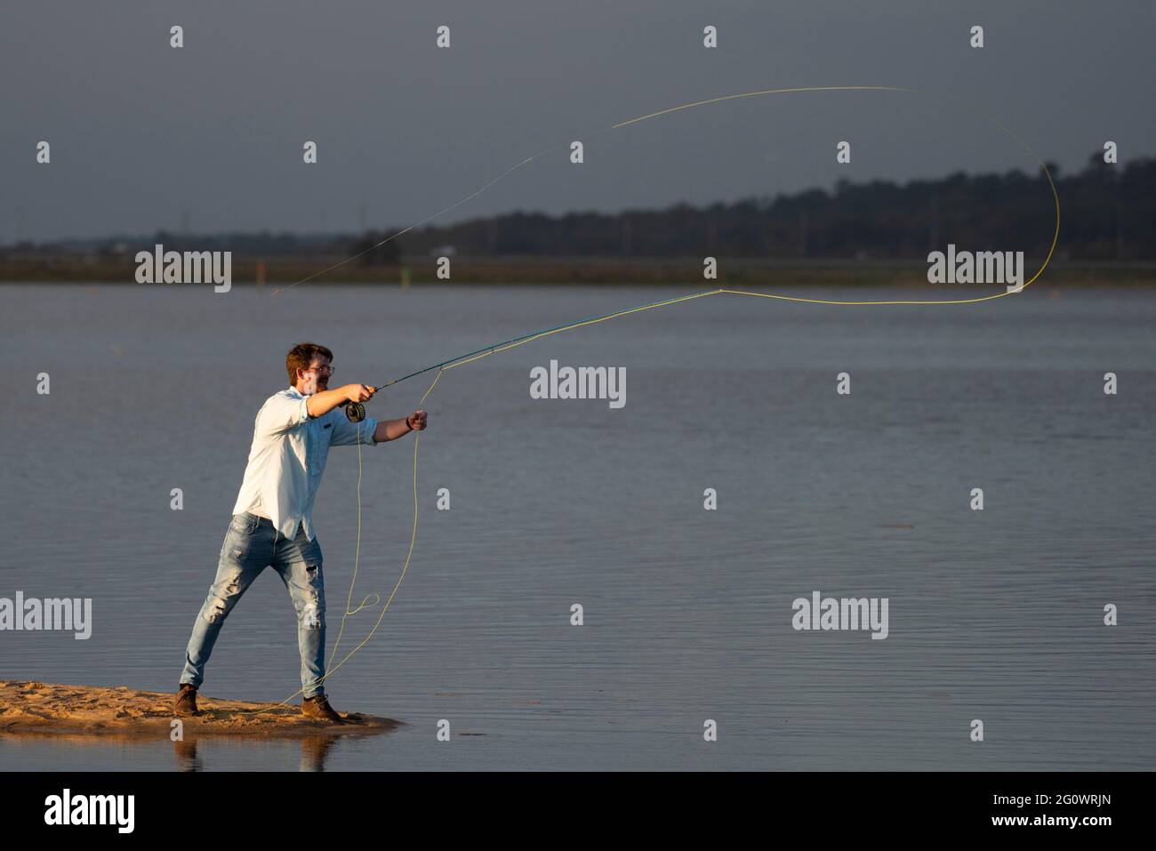 A fisherman casts his line while fly fishing along the Bay of Mobile near Daphne, AL, on Oct. 20, 2020. Stock Photo