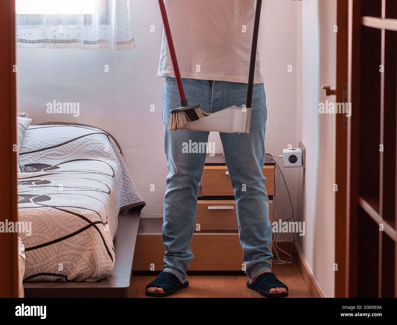 Utility man with a broom and dustpan cleaning the floor Stock Photo - Alamy