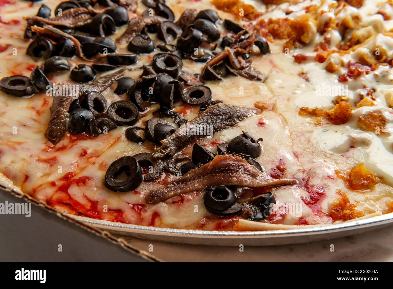 New York style pizza half anchovies and black olives and other half