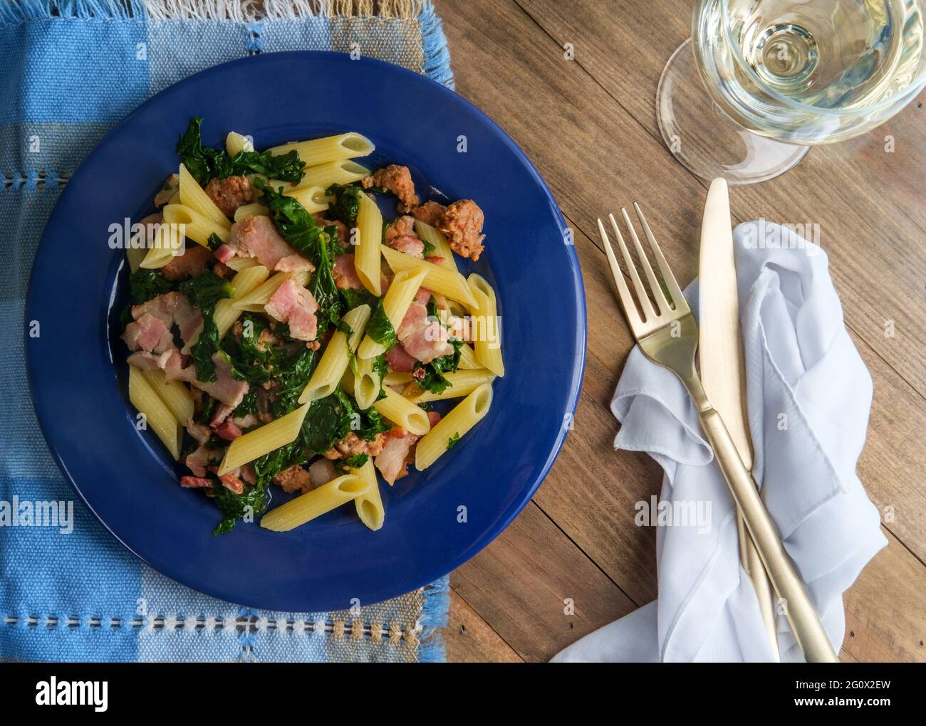 Italian bacon sausage penne pasta in a white wine garlic sause with kale Stock Photo