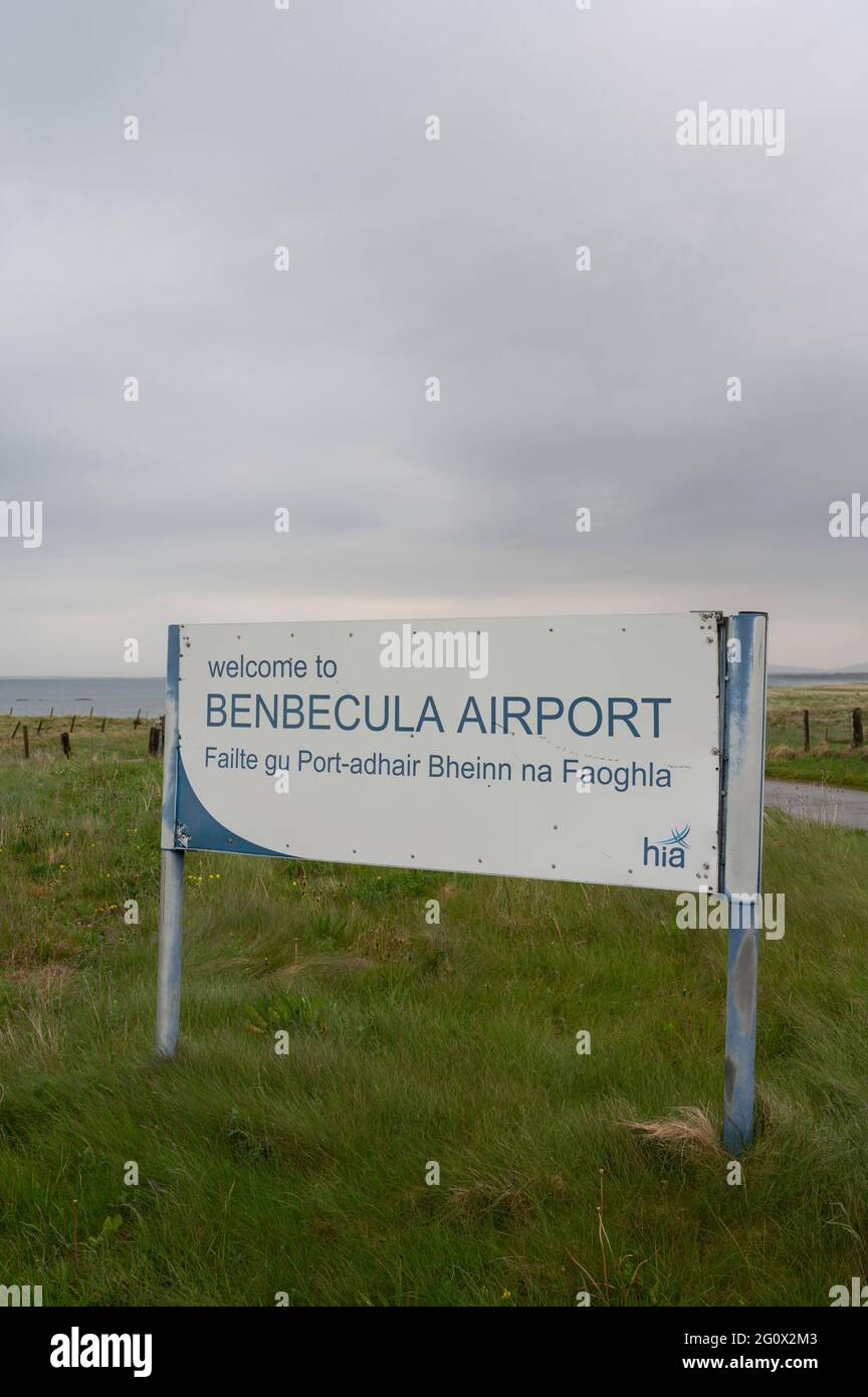 Sign for Welcome to Benbecula Airport with background of grass and ocean on horizon. Copy space. No people. Cloudy day. Stock Photo