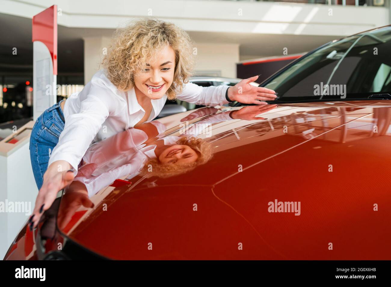 Beautiful Woman Hugging Her New Car In Dealership Happy Girl Rejoices beautiful-woman-hugging-her-new-car-in-dealership-happy-girl-rejoices