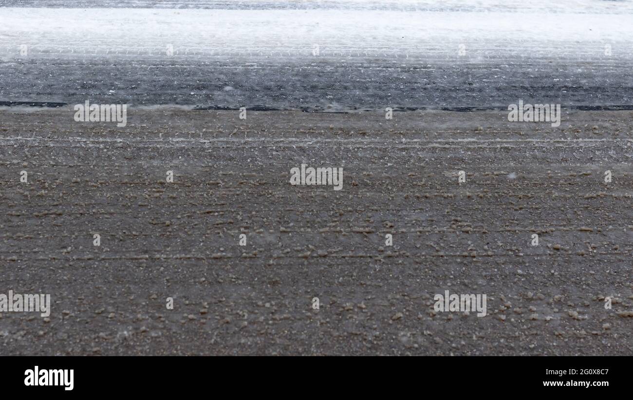 Icy and mushy tire tracks on a road surface Stock Photo - Alamy