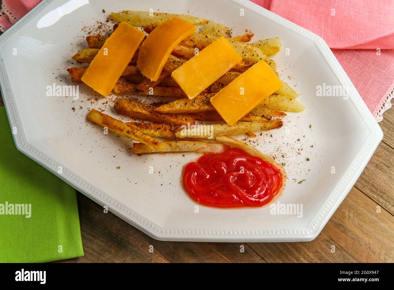 American French fried potatoes with cheese and seasoning Stock Photo