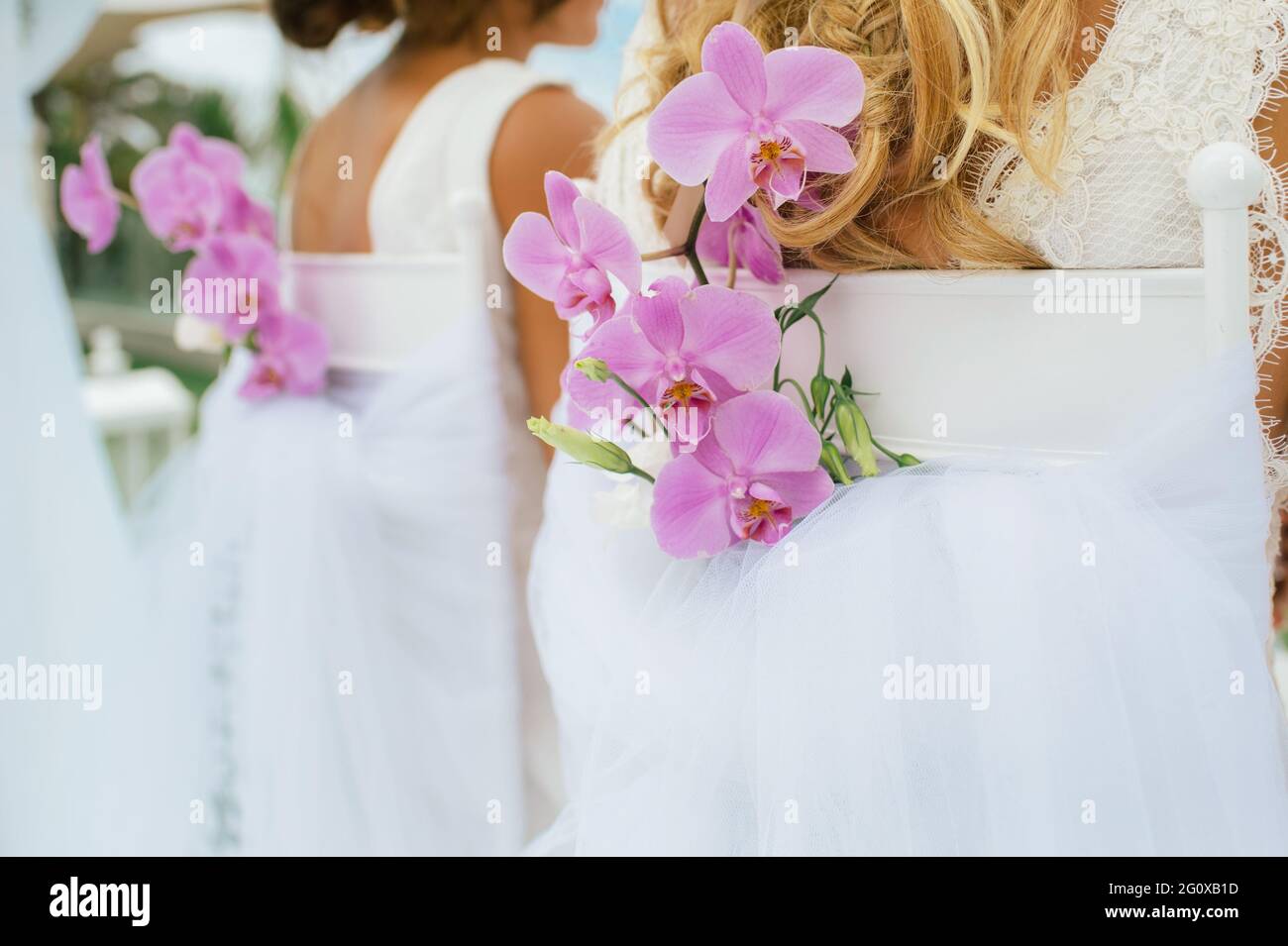 floral decoration on a chair with orchids at a gay wedding of two women. Unrecognisable person Stock Photo
