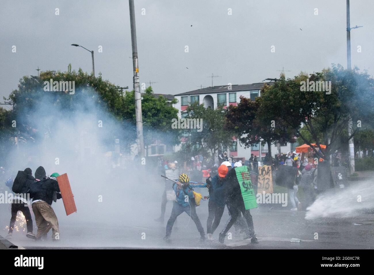 Bogota, Cundinamarca, Colombia. 2nd June, 2021. Demonstrators from the front line cover themselves from water cannons from Colombia's riot police (ESMAD) riot tanks as a new day of anti-government protest in BogotÃ¡, Colombia against the government of President IvÃ¡n Duque and police brutality on June 2, 2021 Credit: Daniel Romero/LongVisual/ZUMA Wire/Alamy Live News Stock Photo